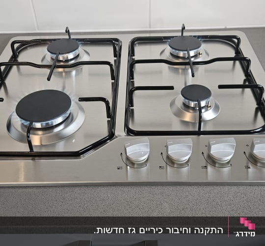 כיריים גז עם ארבעה מבערים וכפתורי שליטה